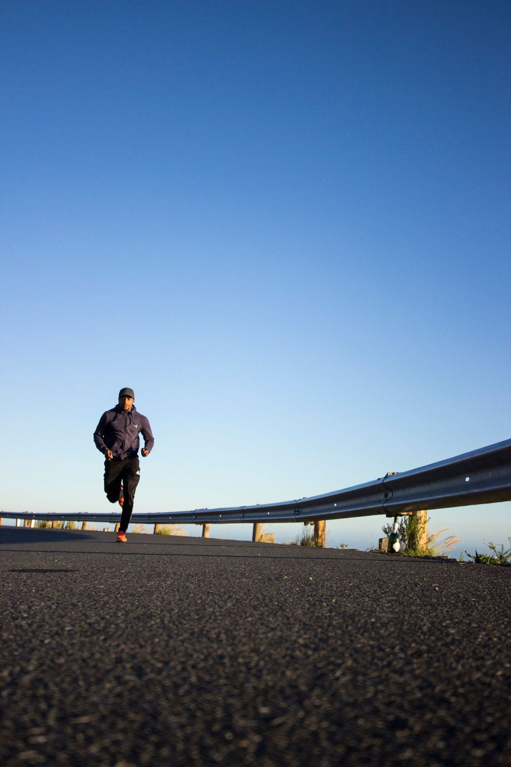 Aktiv mann i 30-årene som jogger ute i naturlig lys