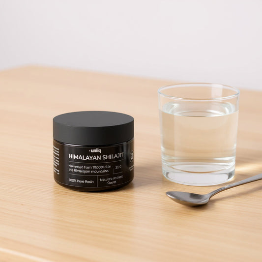 Himalayan Shilajit fra Uniiq ved siden av et glass vann og en skje, klar til dosering